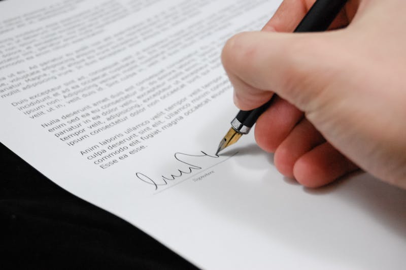 Signing a legal document with pen Signing a legal document with pen